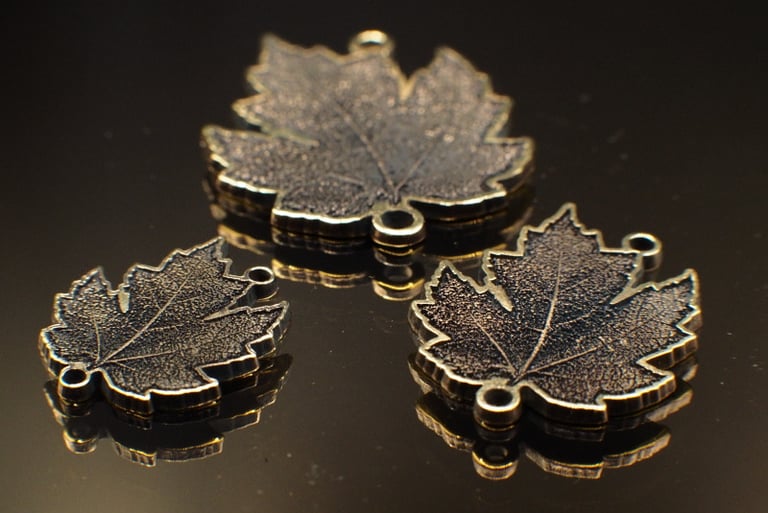 three 3 dimensionally engraved maple leaves with eyelets for ewelry, home made on whyte avenue