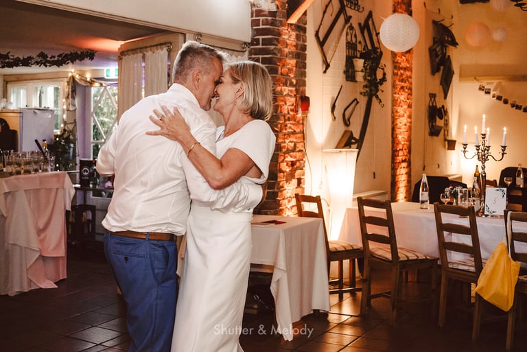 A mature couple slow dancing during a wedding reception.