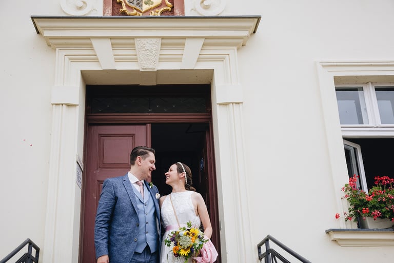 Newly wed couple smiling in front of the old town hall in Werder.