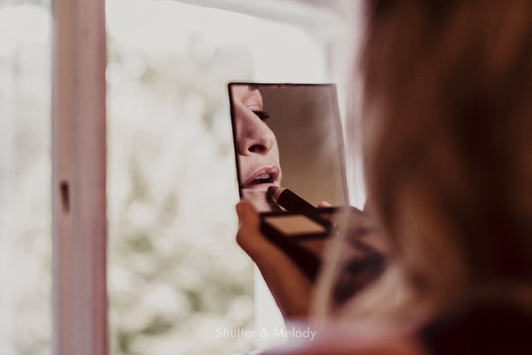 Braut, die sich die Lippen mit einem Stift schminkt.
