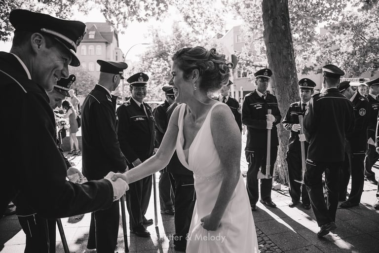 Bride shaking hands with firemen.