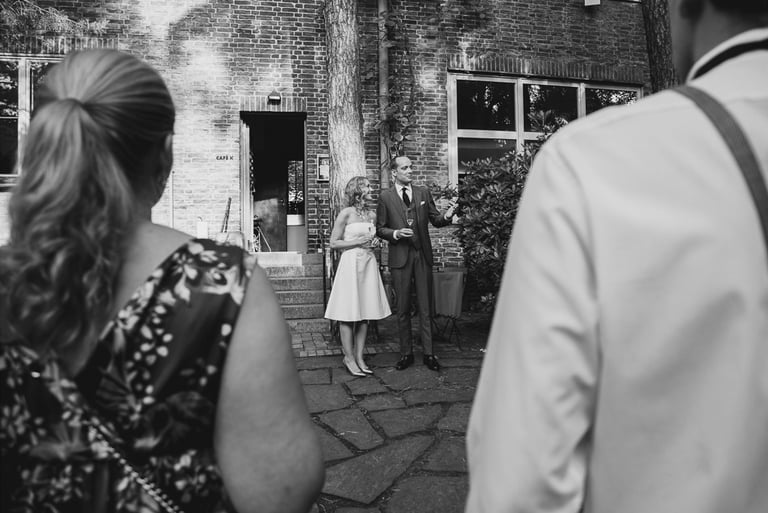 Bride and groom giving a speech outdoors.