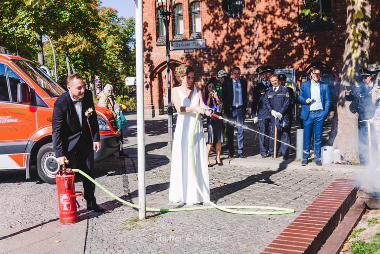 Bride and groom extinguishing a fire.