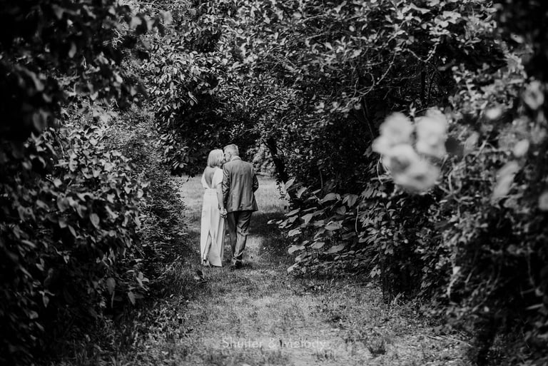 A couple having an intimate moment walking in a garden.