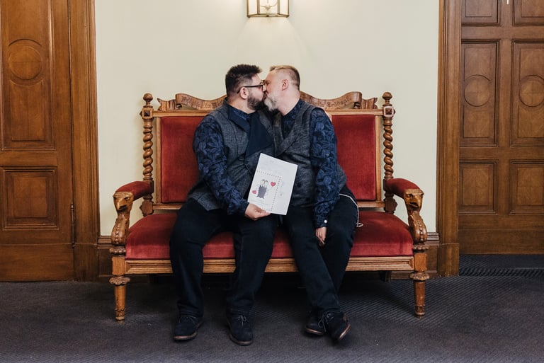 Gay couple kissing holding their marriage certificate.