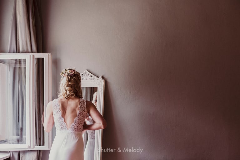 Bride looking at herself in the mirror.