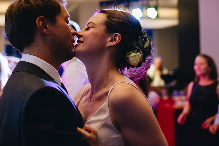 Bride and groom drinking wine under a Just Married sign.