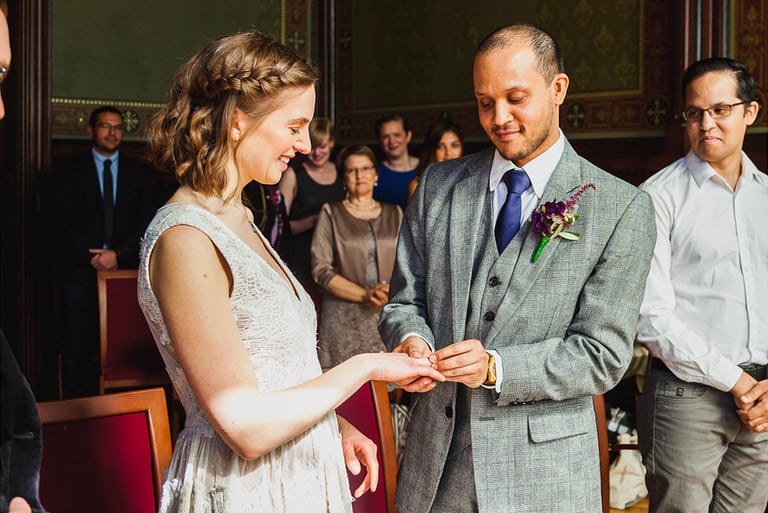 Bride and groom exchanging rings during wedding ceremony.