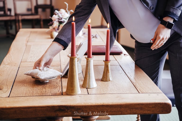 Trauredner legt ein Kissen mit Ringen auf einen Tisch.