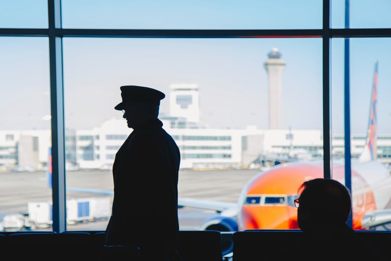 a man in a uniform is standing in front of a window