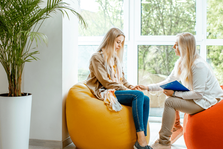 two women sitting on bean bags in a room