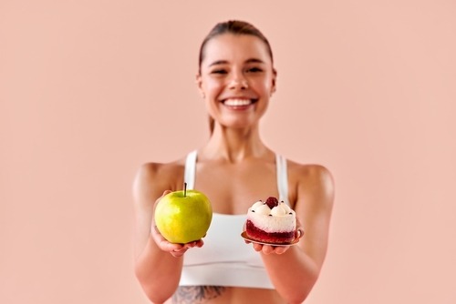 a woman holding a cake and a cupcake
