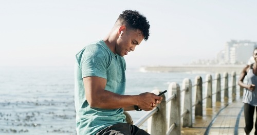 a man sitting on a bench looking at his cell phone