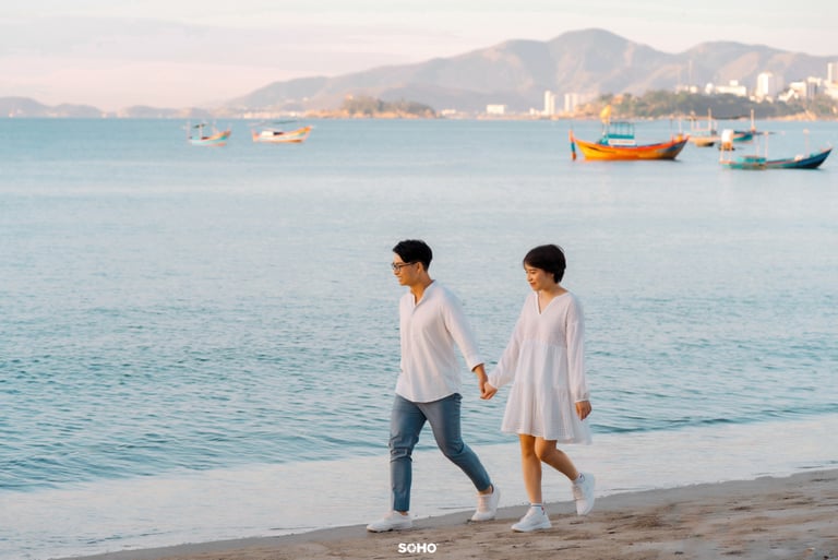a man and woman walking on the beach