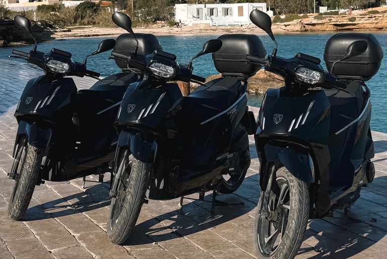 three motorcycles parked on a brick wall near a body of water