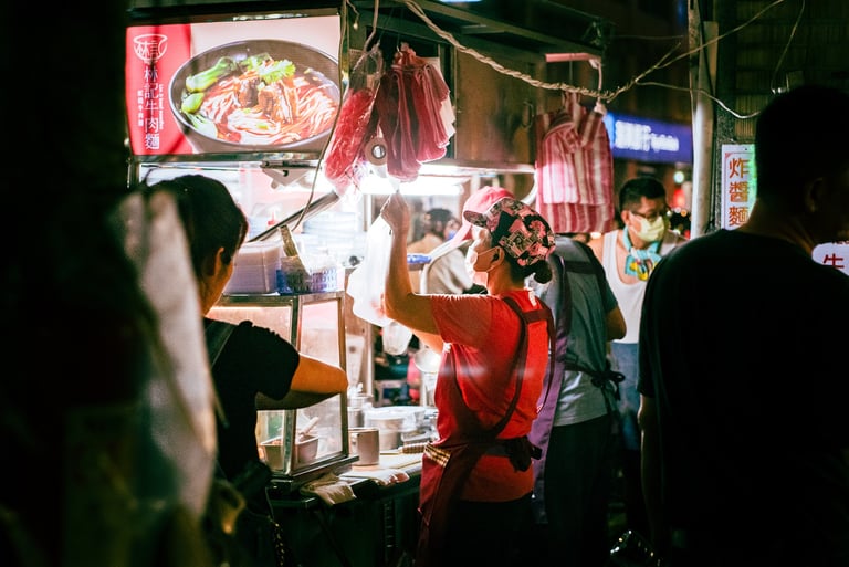 a woman is standing in front of a food vendor in Taiwan