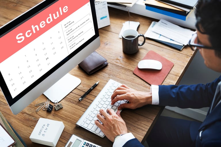 Two people discussing their schedules or appointments, with a focus on the calendar or scheduling ap