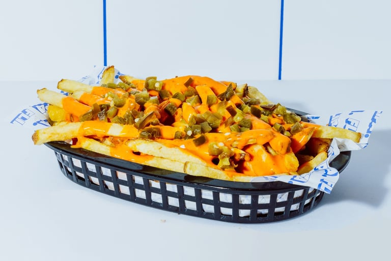 Patatas fritas de Flipa cortadas a mano diariamente, con mayo chili y jalapeños