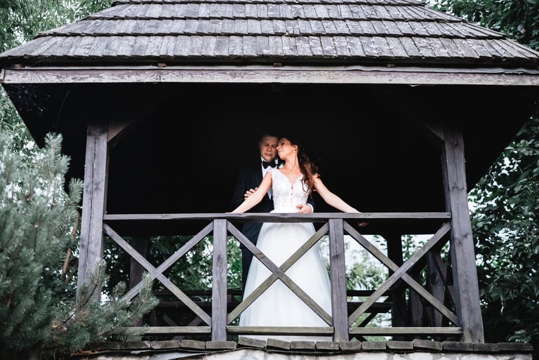 a bride and groom kissing on a gazeboar