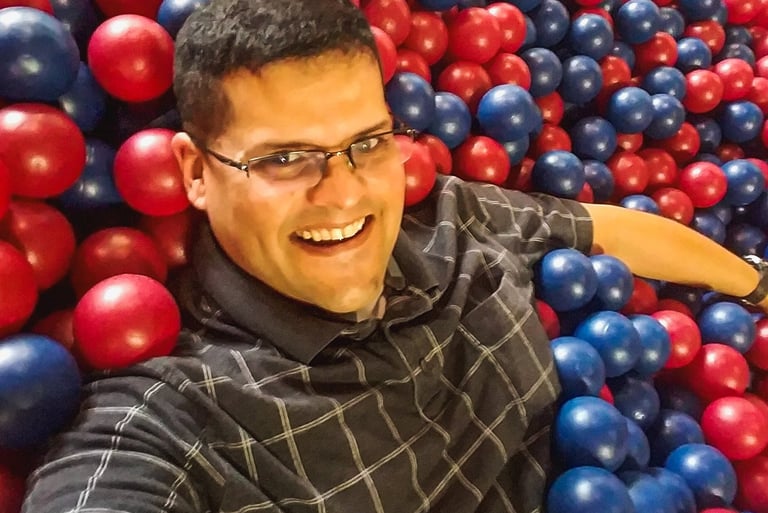 Man with glasses in a ball pit