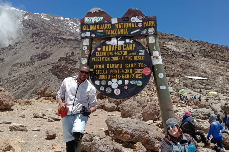 a man and woman standing in front of a sign