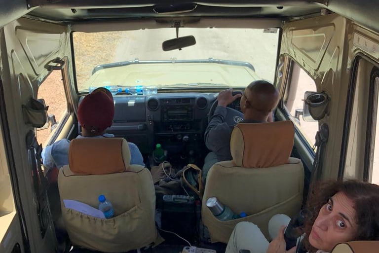 a woman sitting in a vehicle with two men