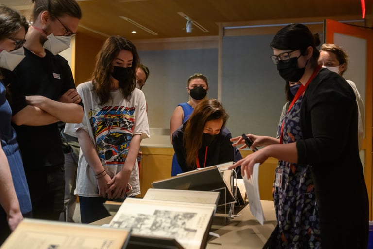 a group of people standing around a table looking at books