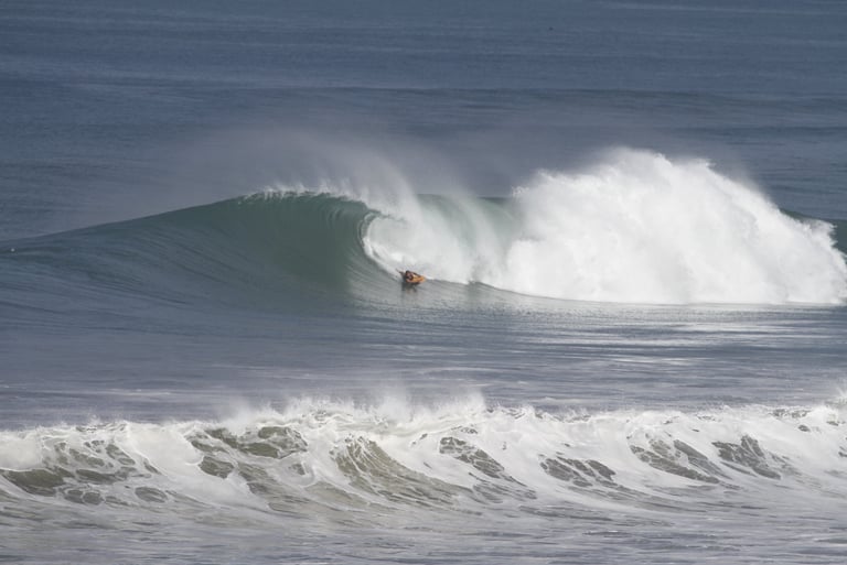 Surfer guide riding a perfect wave at an ecuadorian beach break