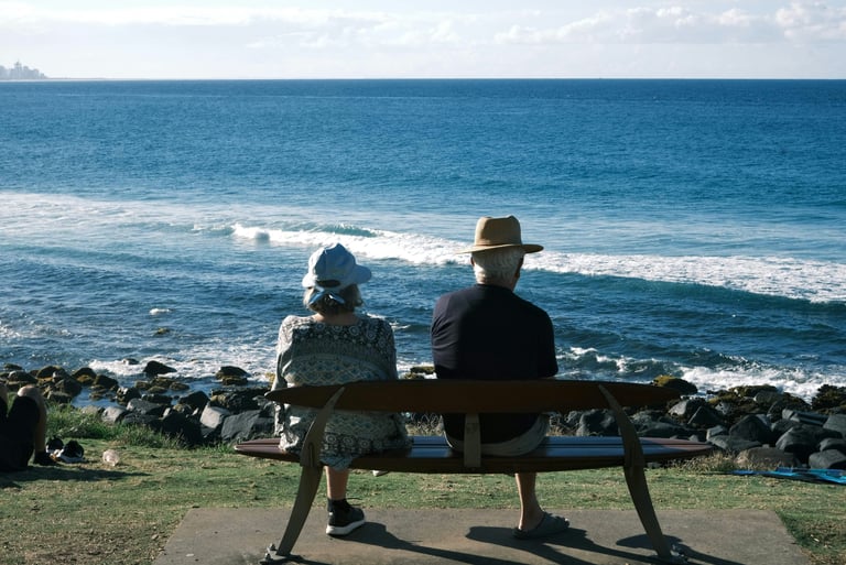 A retired couple sat on a bench looking out to sea