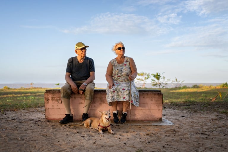 Un couple de personnes âgées et leur chien en bord de mer