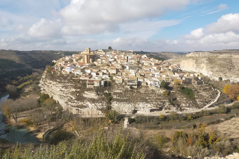 a small town on a hill with a river running through it