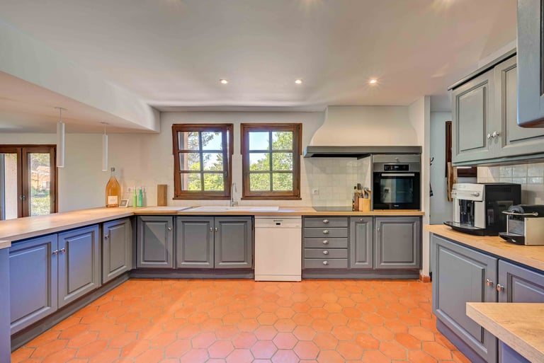 a kitchen with a tile floor and a large window