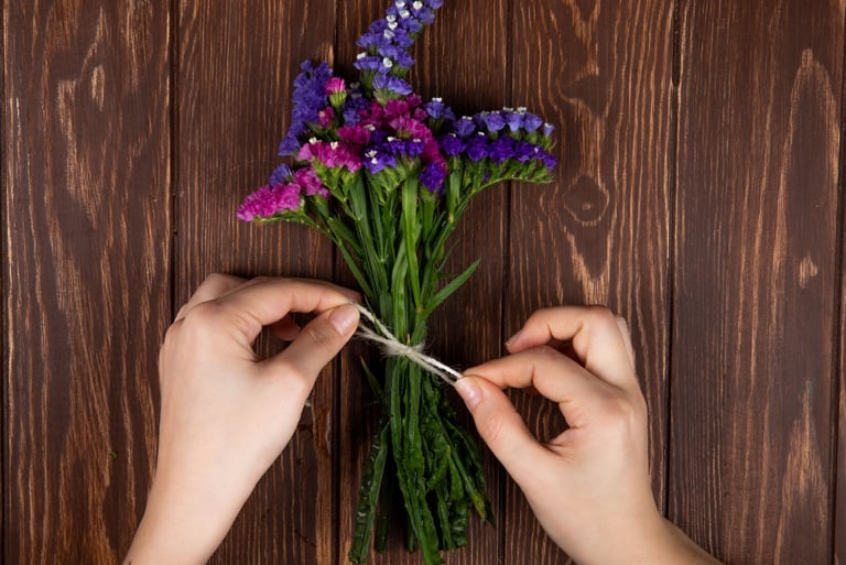 unas manos atando un arreglo florar de crochet de lavandas.