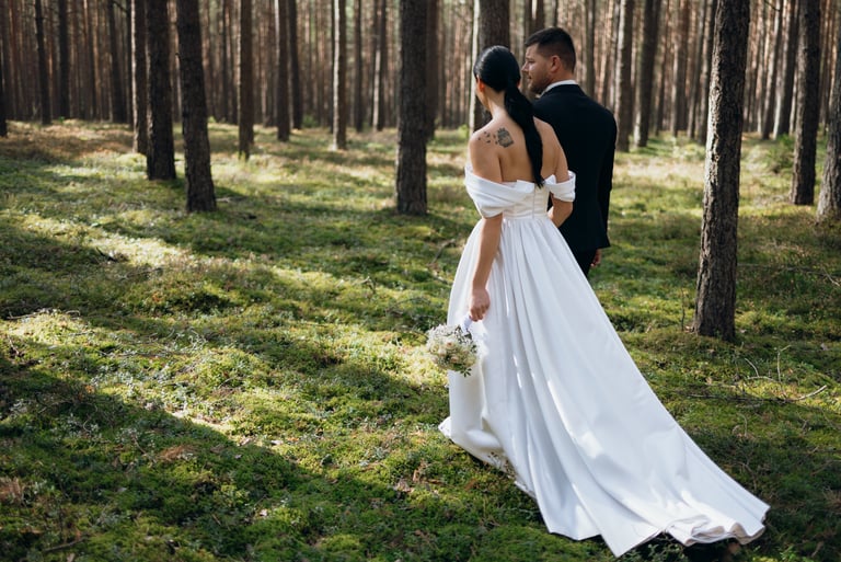 Vestuvių fotografija - jaunikis ir nuotaka eina mišku