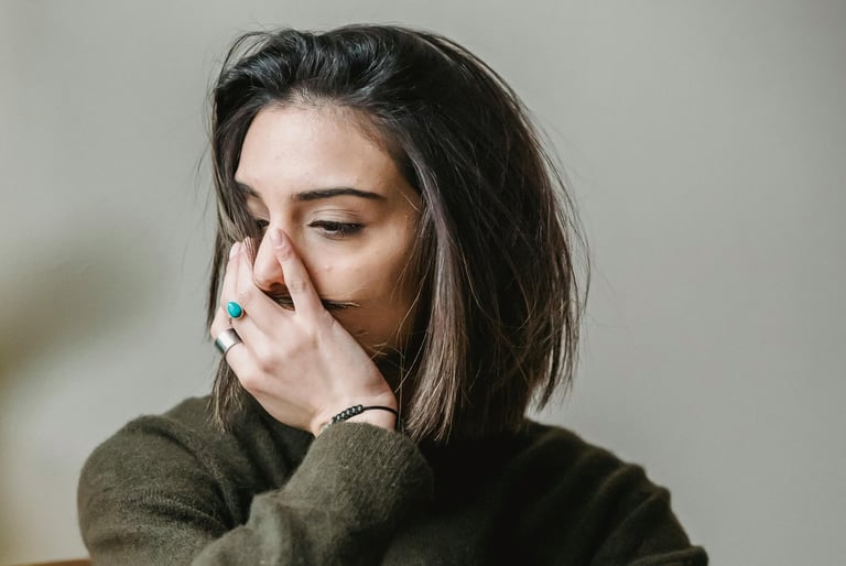 femme dont le visage et la posture indique une difficulté émotionnelle