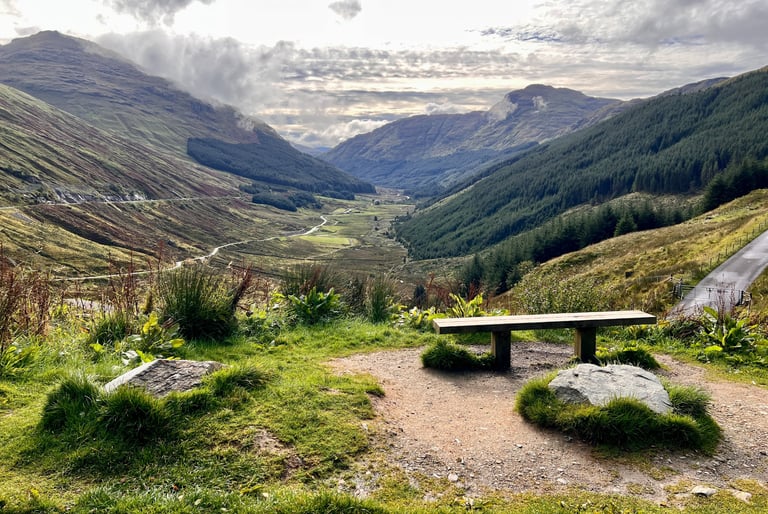a bench overlooking the scenery in the mountains