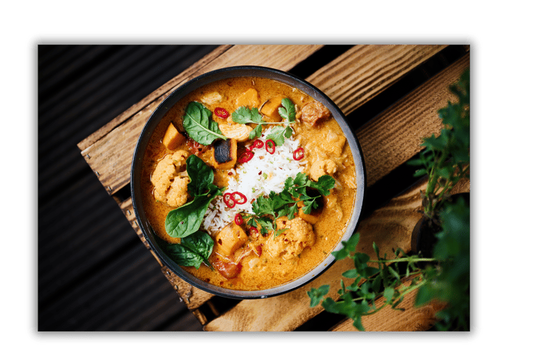 a bowl of food with a wooden table and a potted plant