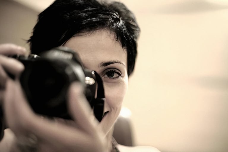 a woman with short hair taking a picture WITH A CAMERA in her hand