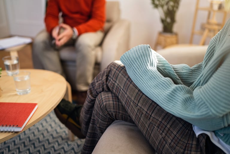 Two people in a comfortable therapy session, representing telehealth therapy with Paula Fontenelle