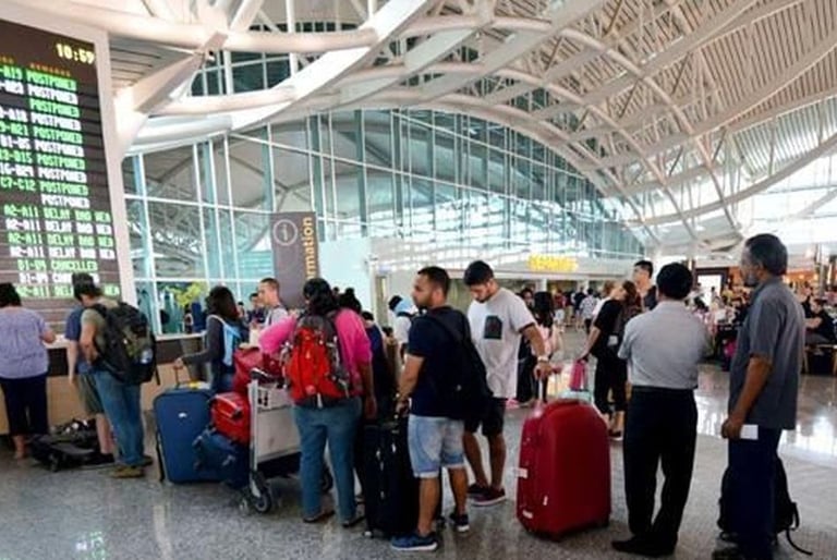 view of an airport with tourists standing in que