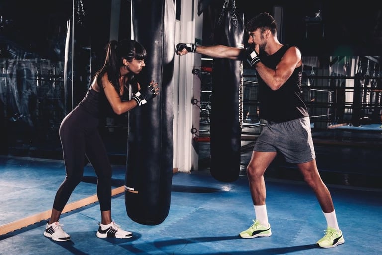 a man and woman boxing training in a gym