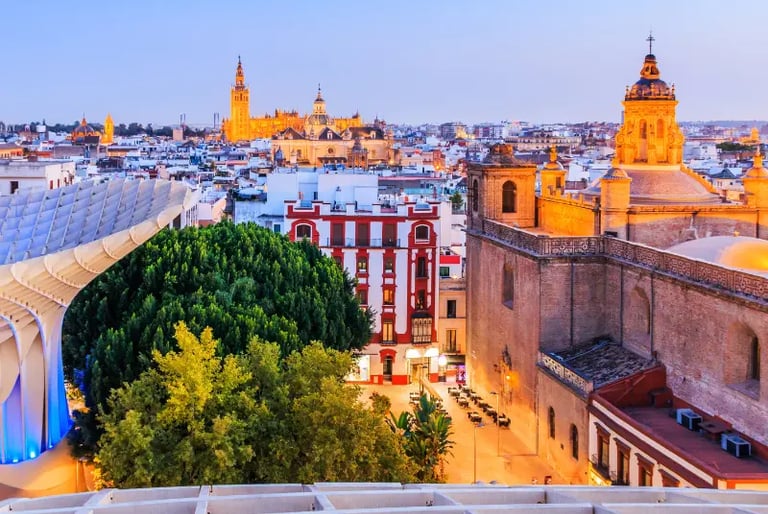 Sunset view of the Seville skyline featuring the Cathedral, Giralda tower, and Metropol Parasol.