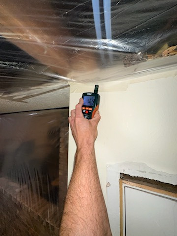 Moisture readings being taken on wall