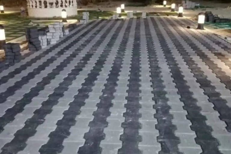 تركيب بلاط متداخل (إنترلوك) لتجهيز ممر حديقة بالكويت، يظهر مع إضاءة أرضية ونافورة