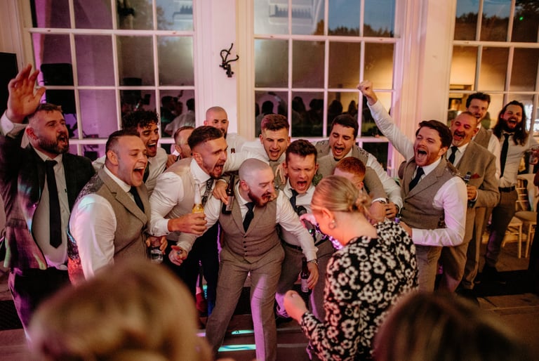 Groom and groomsmen having fun at wedding party