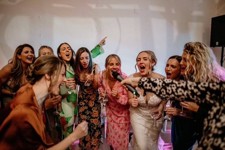 bride and bridesmaids singing with wedding party band