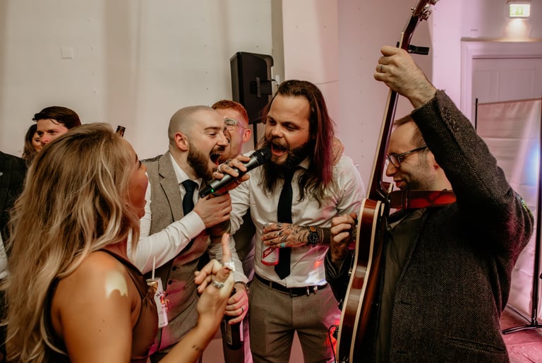 groom and groomsmen singing with wedding band