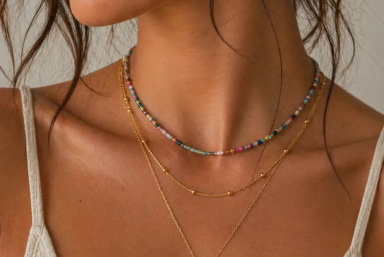 A woman wearing a layered gold necklace set with a colorful beaded choker and a dainty sun pendant.