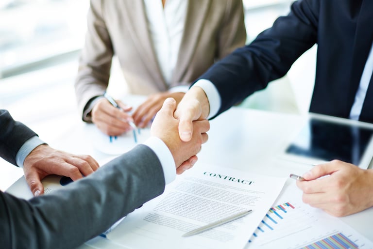 a group of people shaking hands over a table