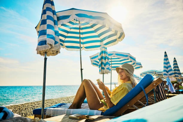 a woman sitting on a beach chair with a book